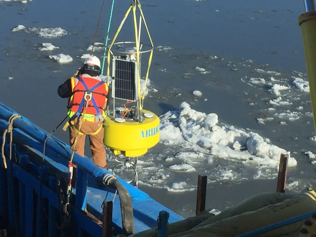 Technicians installing Aridea’s buoy in the water Technicians installing Aridea's buoy in the water